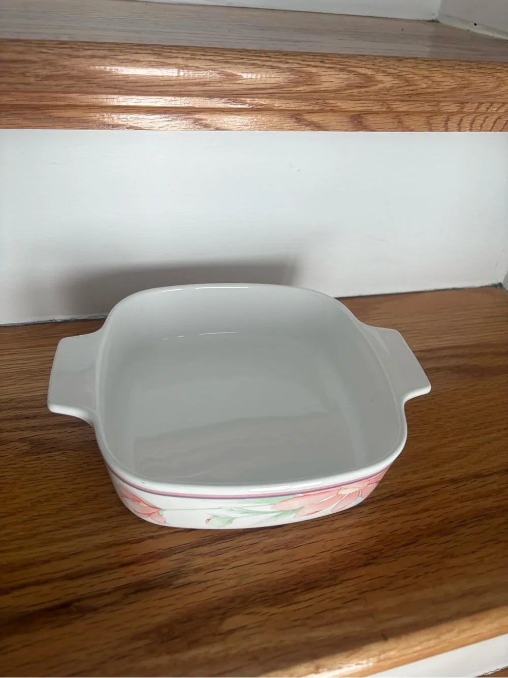 A vintage Corning Ware casserole dish in the Peony Floral pattern with lid